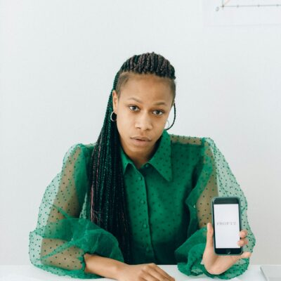 Woman in Green and White Floral Long Sleeve Shirt Holding White Iphone 4